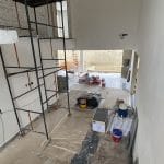 Proses renovasi interior rumah dengan pekerja dan material bangunan