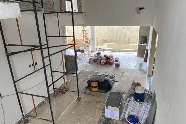 Proses renovasi interior rumah dengan pekerja dan material bangunan