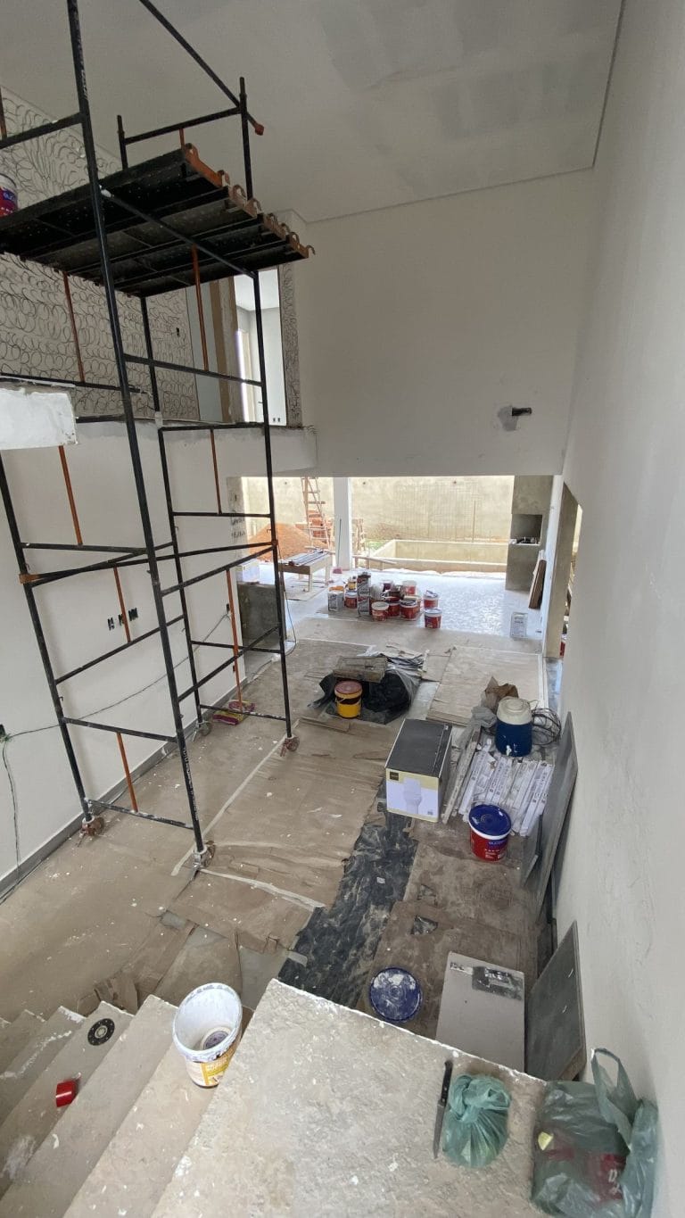 Proses renovasi interior rumah dengan pekerja dan material bangunan