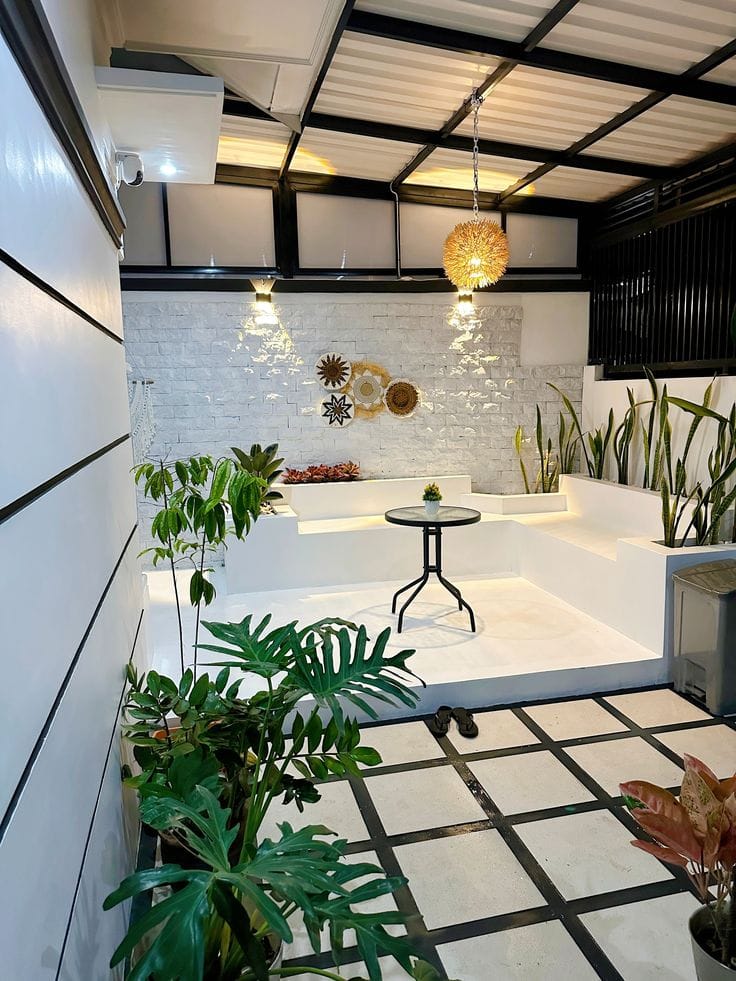 Teras rumah modern dengan tanaman dan meja makan di area semi outdoor